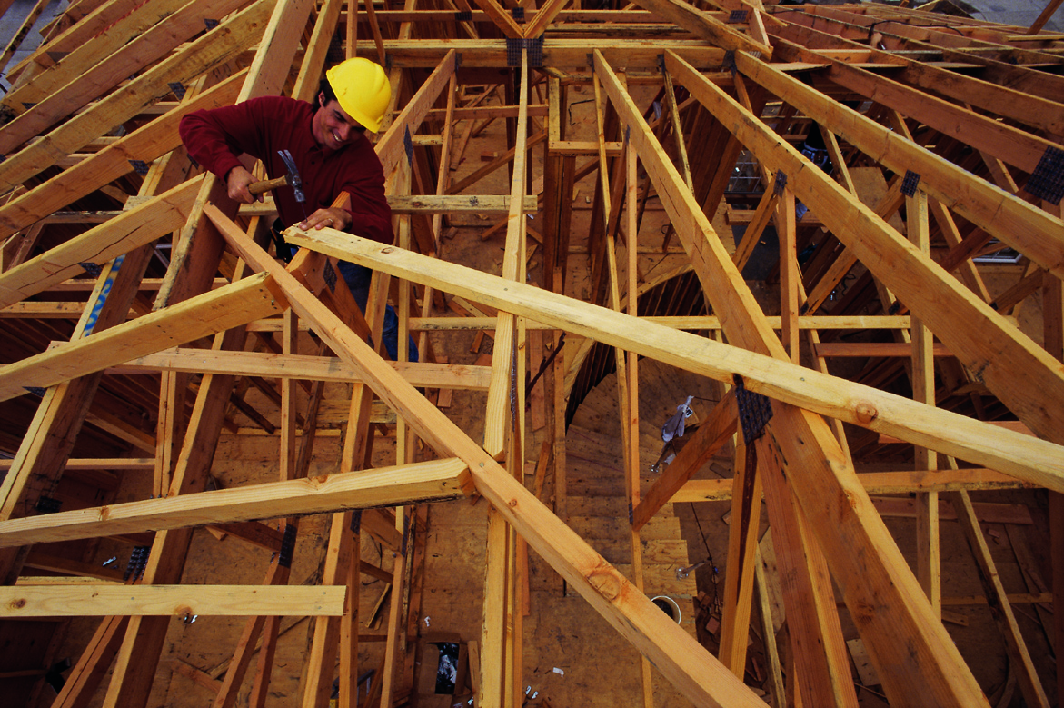 Man constructing timber roof frame.