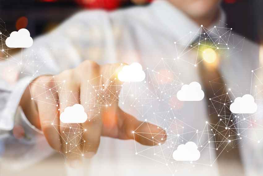 Businessman pointing at digital clouds