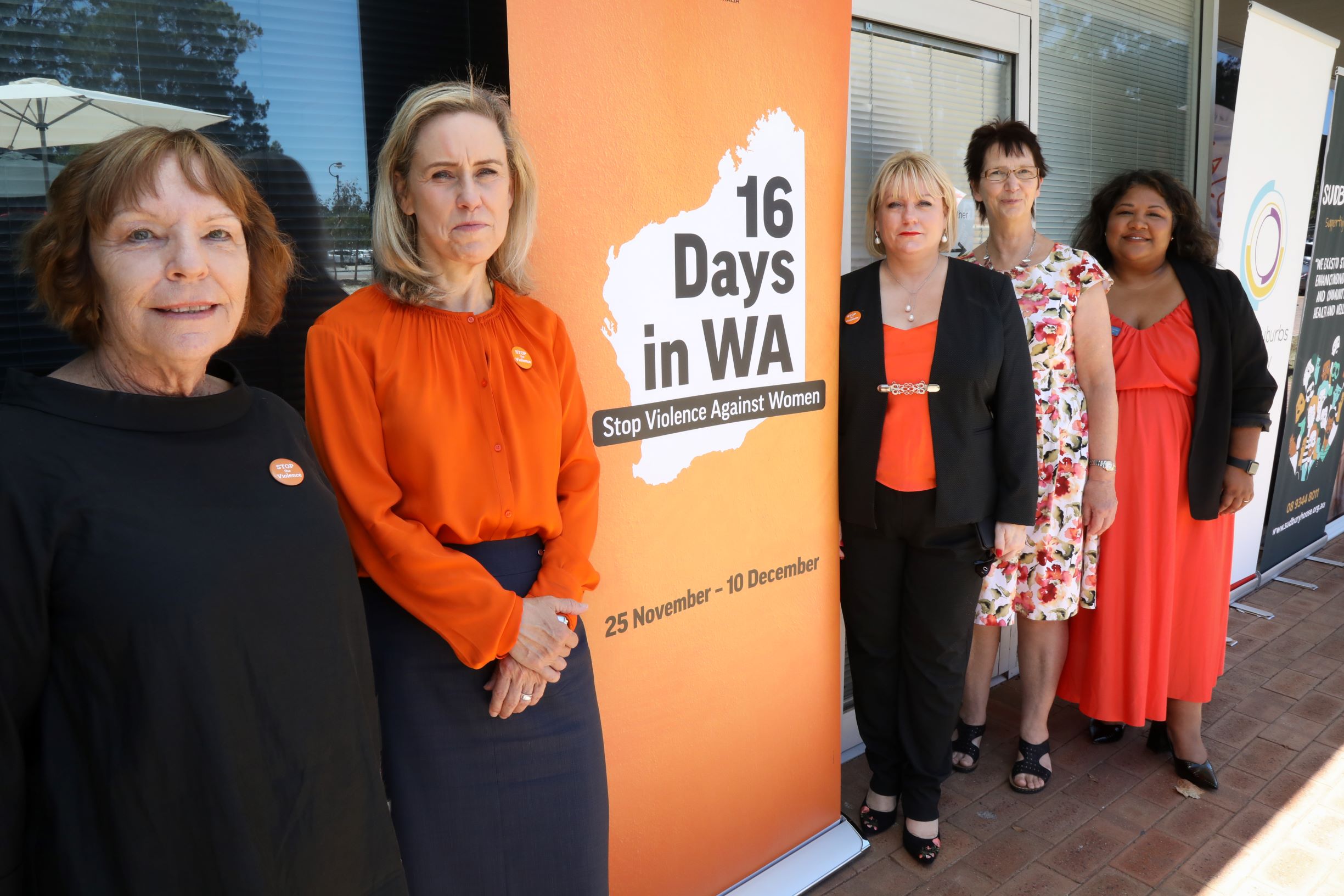 Minister McGurk at the launch of two new family and domestic violence hubs. The minister is standing in front of an orange 16 Days in WA banner.