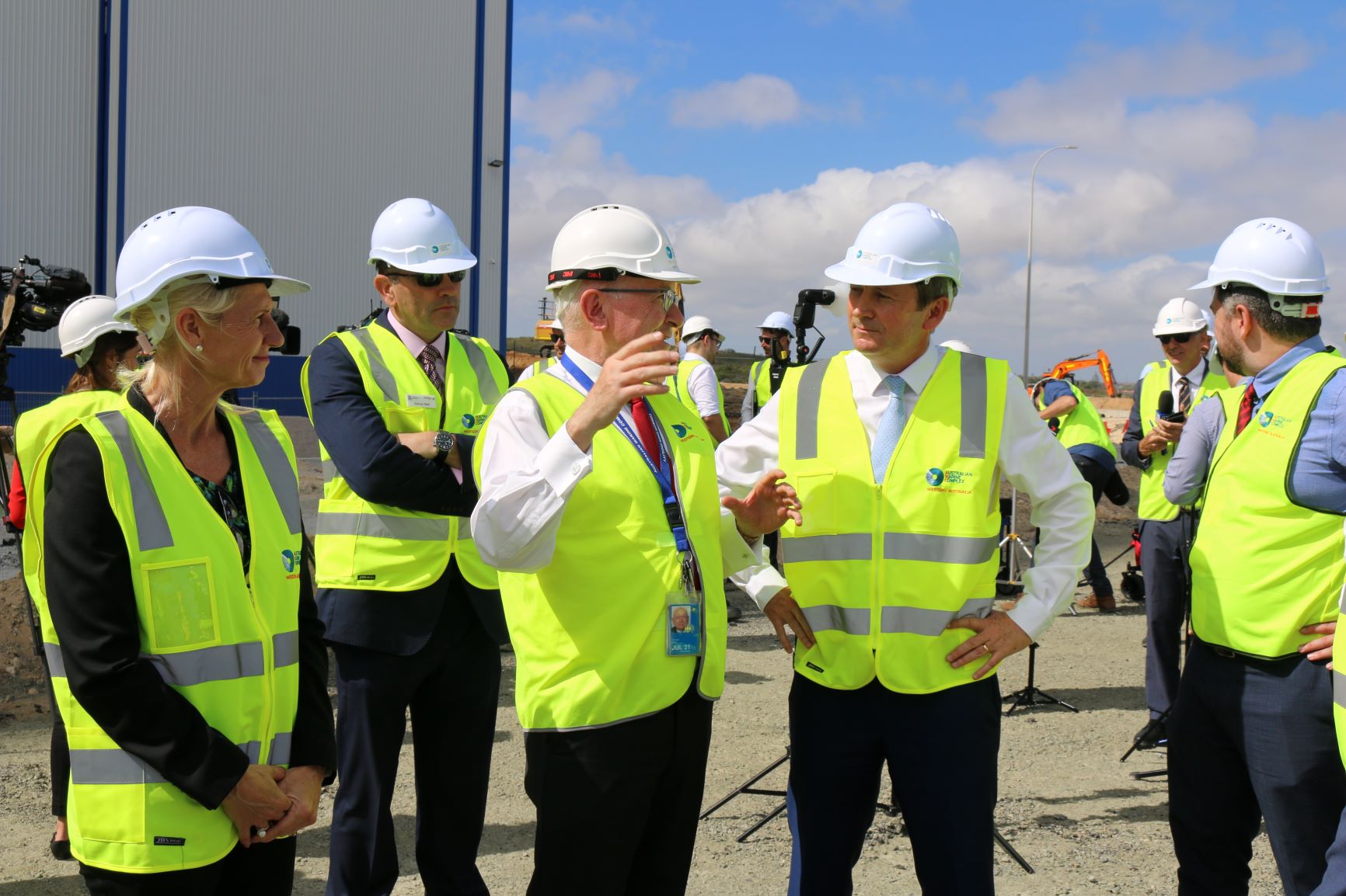 A group of men and women stand in a group wearing yellow high vis and white helmets. The people include the Premier of WA and key staff from the Department of Jobs, Tourism, Science and Innovation.