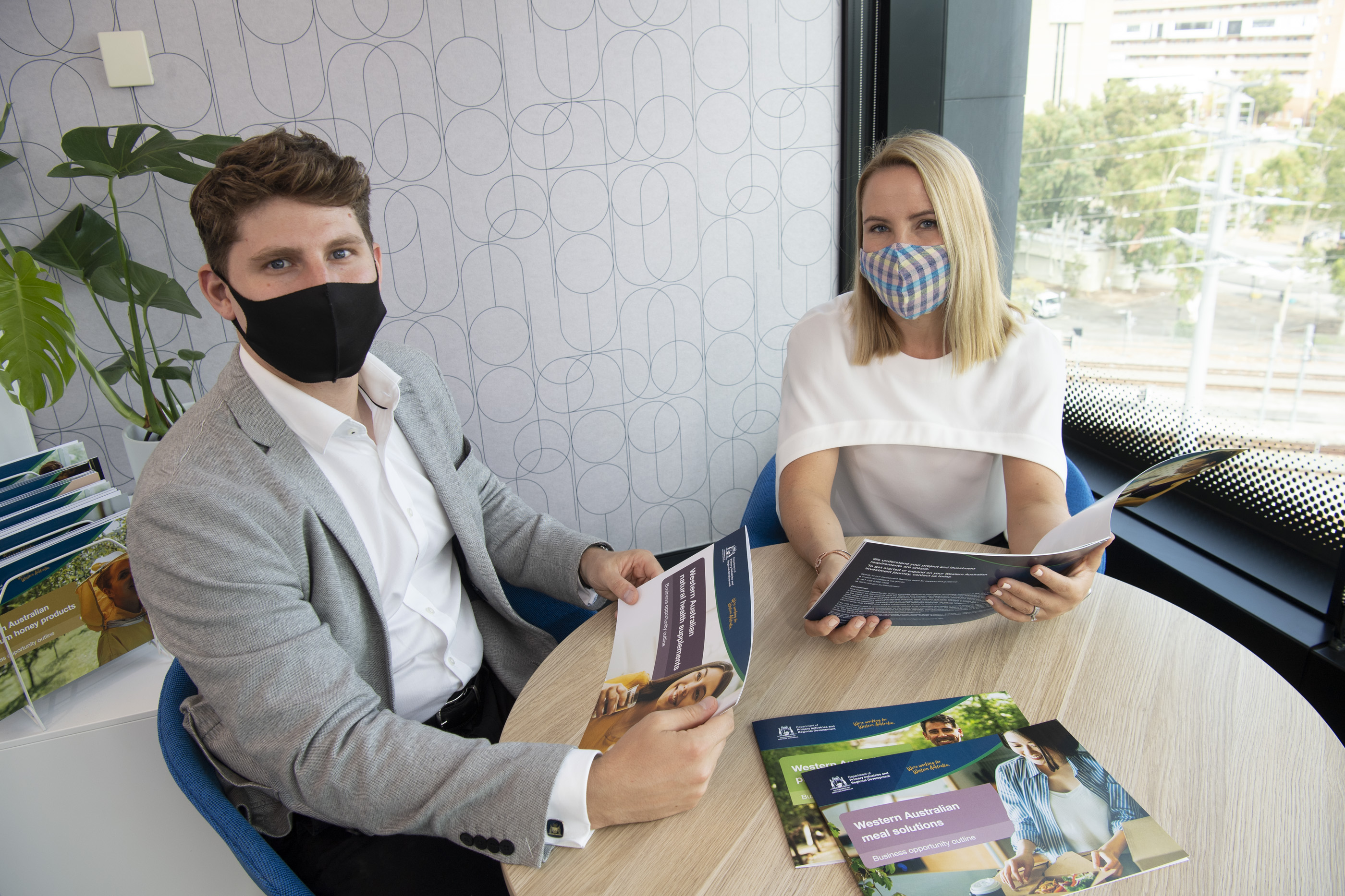 DPIRD staff members reading pamphlets describing agrifoods business opportunity 