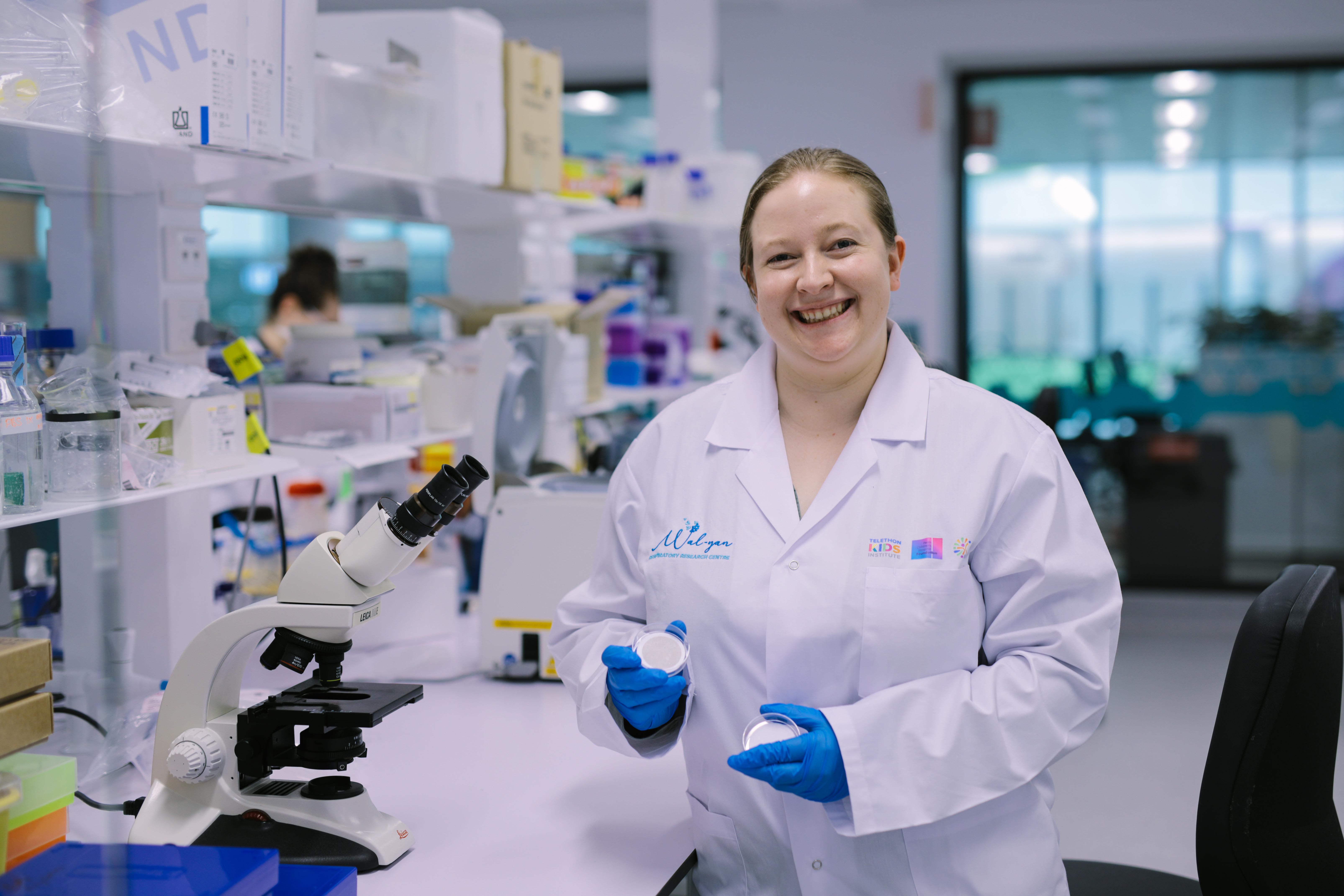 Katherine Landwehr in a lab holding a glass