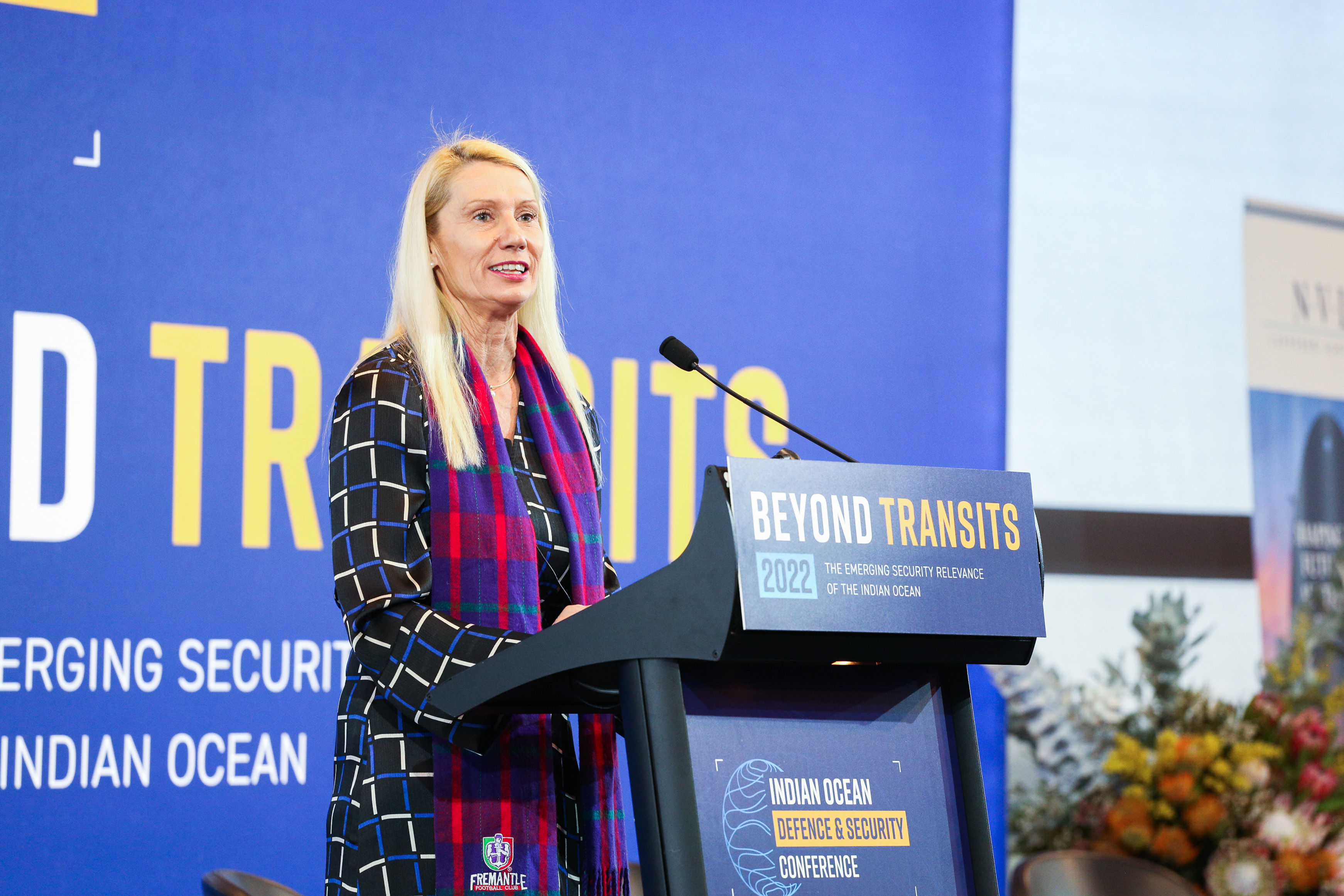 Linda Dawson stands at a podium presenting at the conference