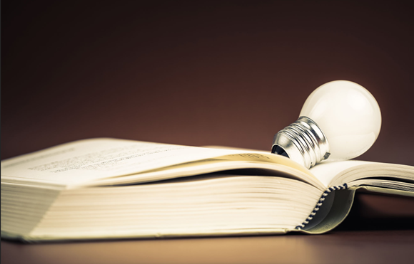 Lightbulb sitting on a book.