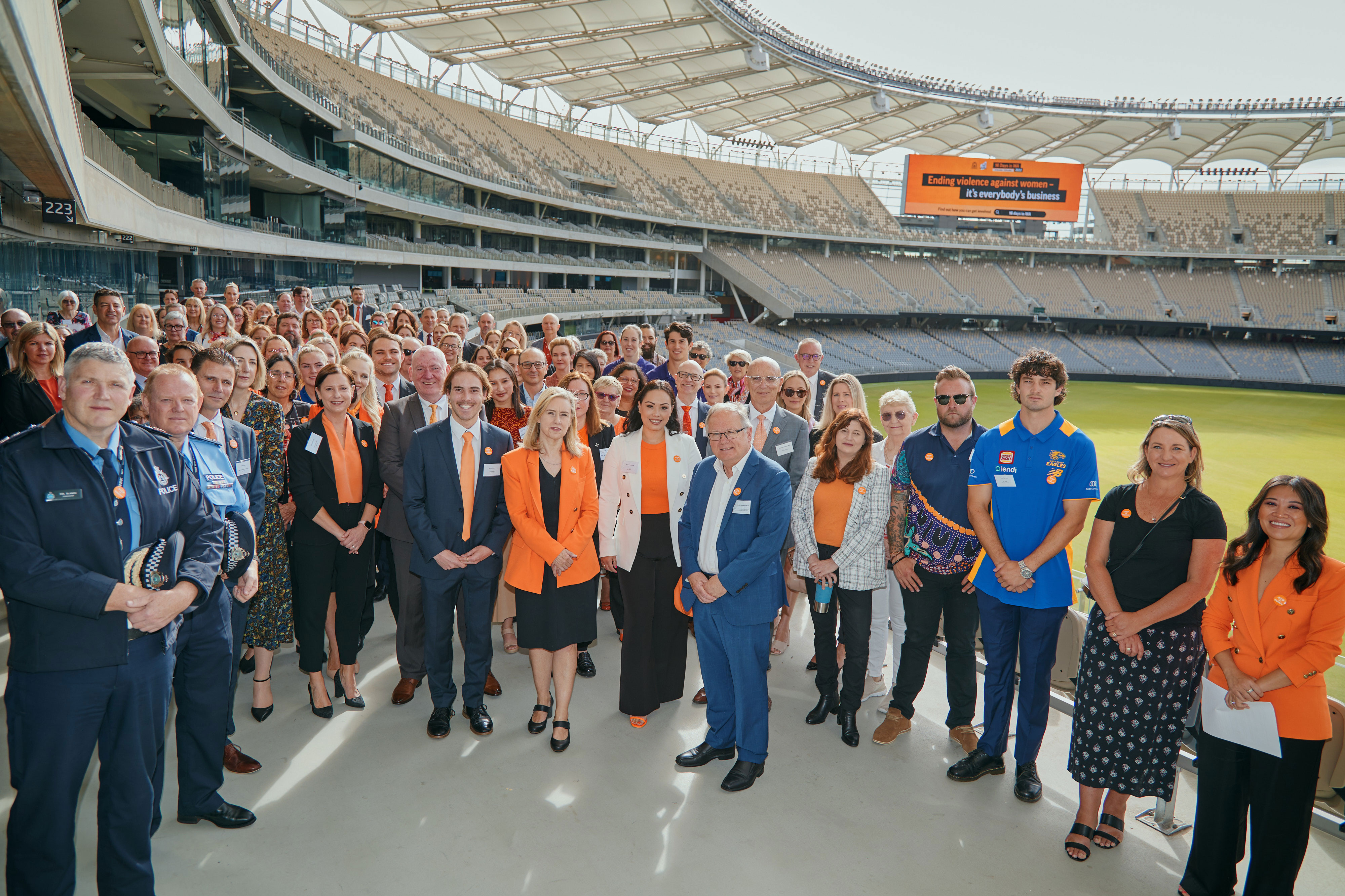 Photo of large group posing in grand stand at Optus Stadium