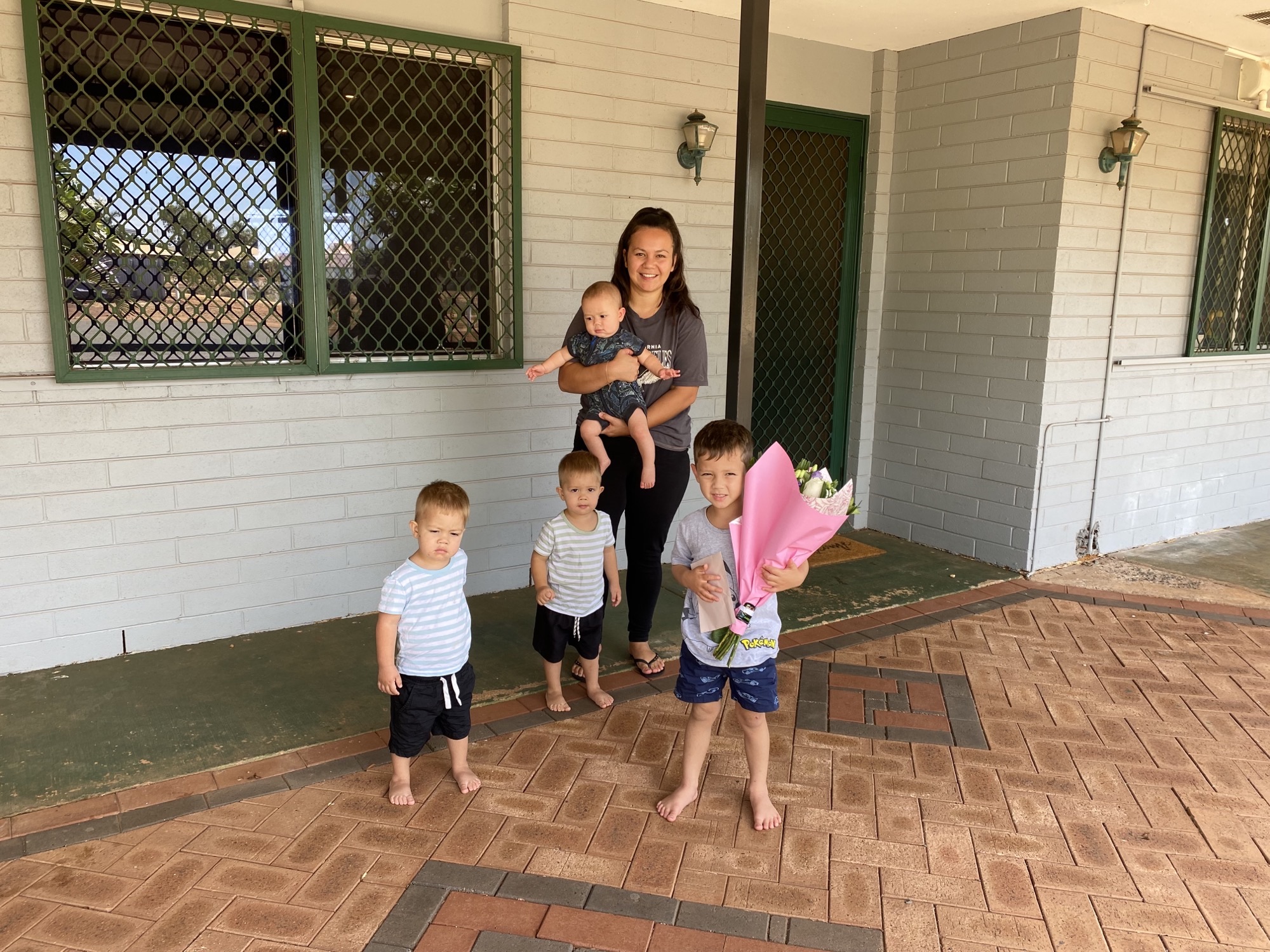 Mum and kids standing in front of their new home