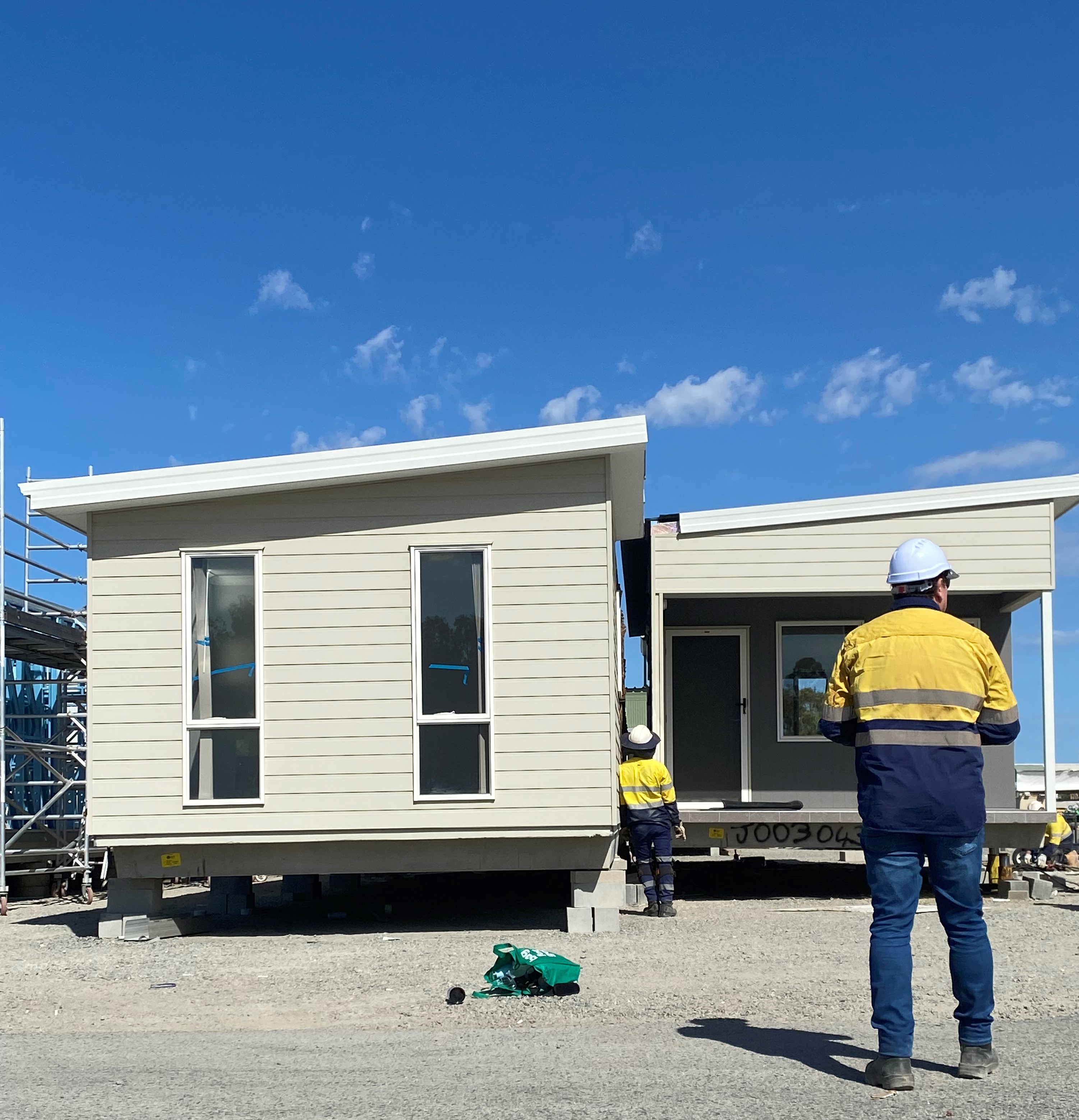 image of construction workers outside a social housing home being built