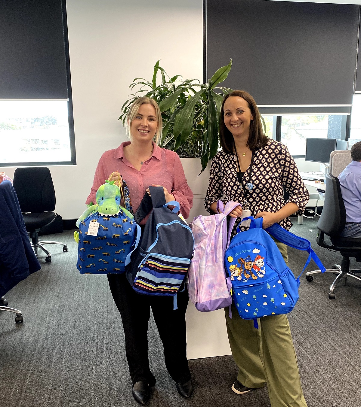 Photo of Communities staff members Charlotte Newton and Rosanna Blake with their Care Bags for children in care.