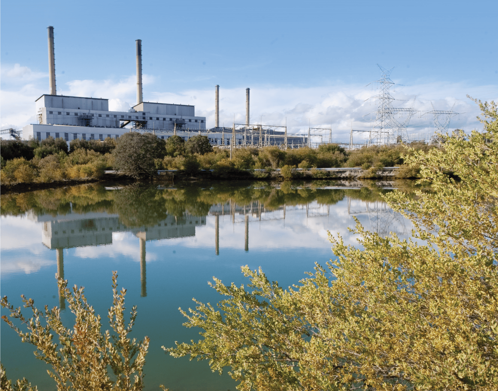 a lake next to transmission lines