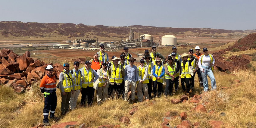 A group photo of graduates in the Pilbara. They are wearing high-vis vests. 