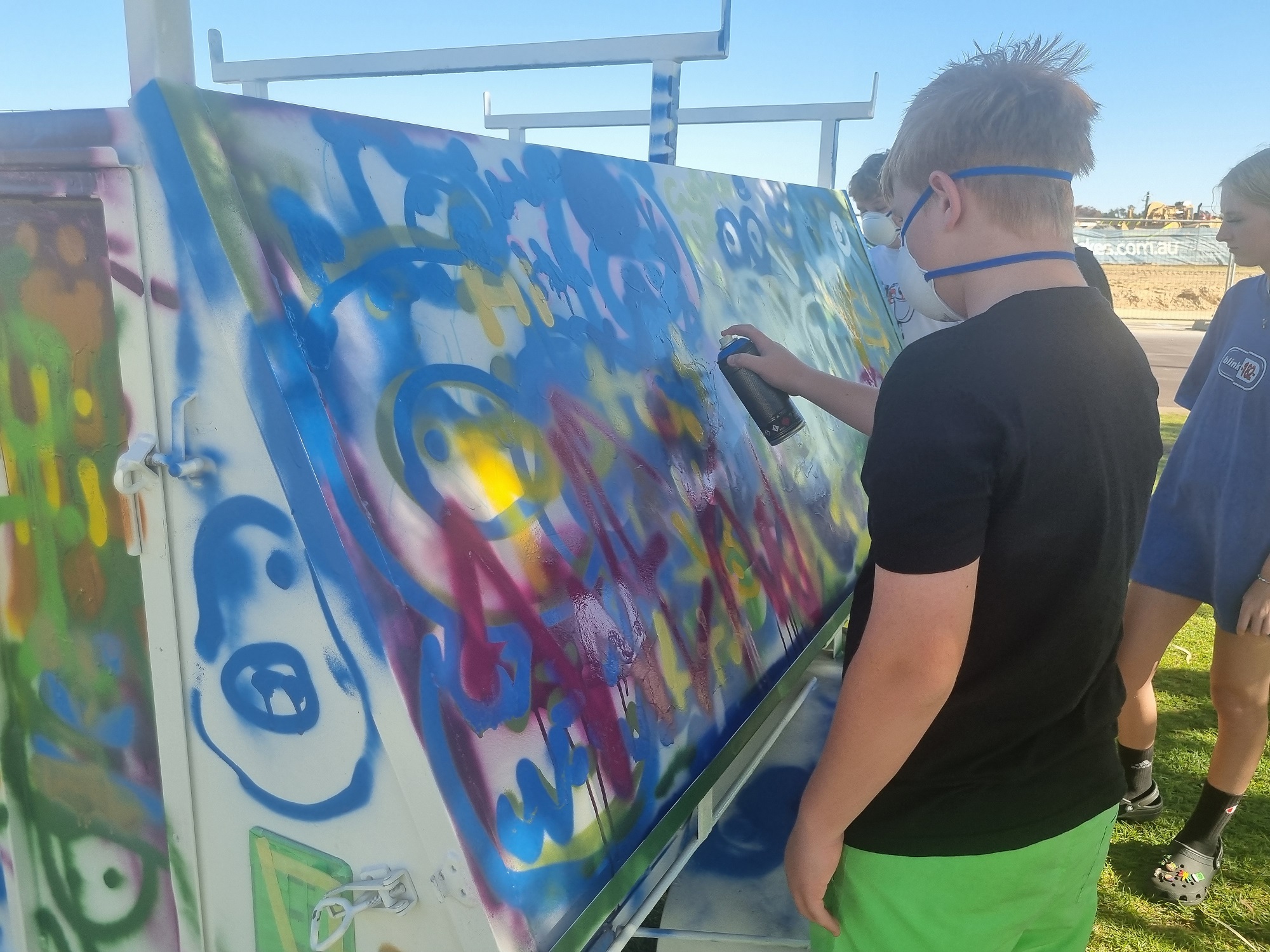 Photo of young people creating artwork with spray cans