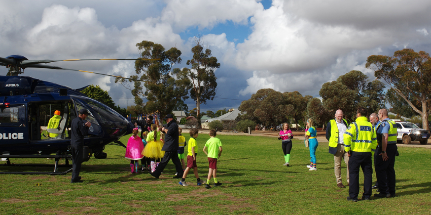 A police chopper lands on the lawn on an oval in Narembeen for SOCK week