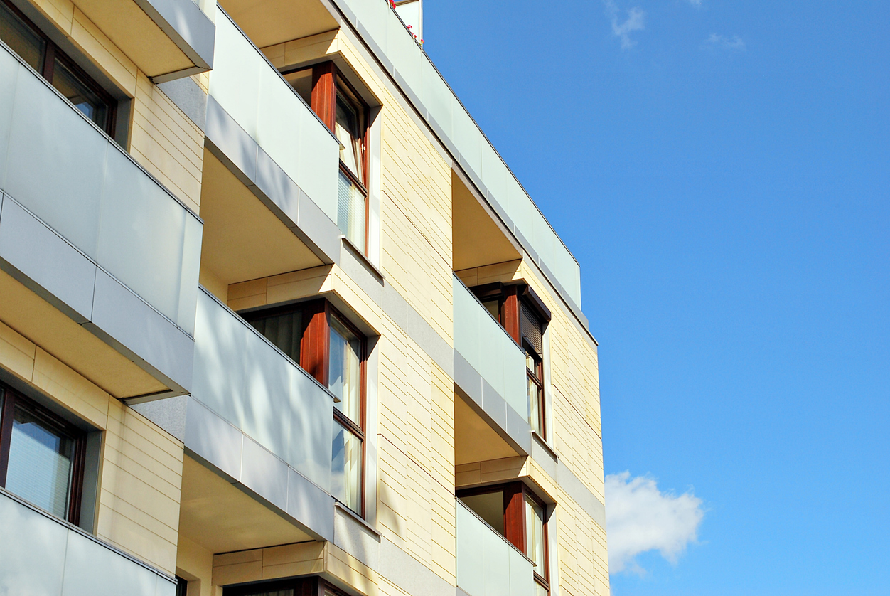 photograph of an small apartment complex with blue sky in the background