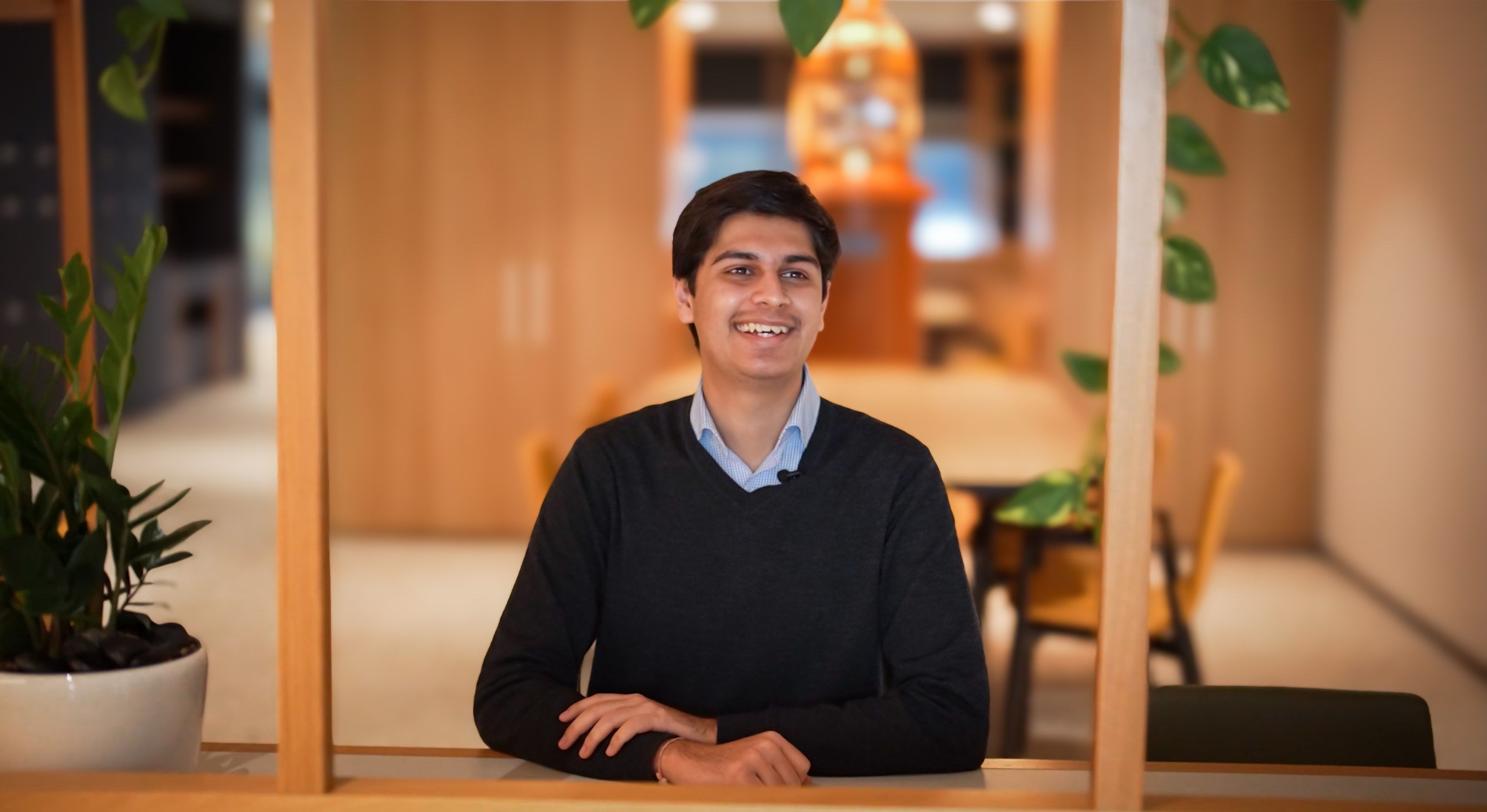 Image of a young man sitting at a desk in an office environment