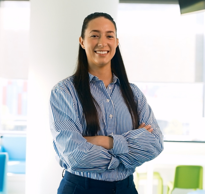 A woman wearing a business shirt stands in an office