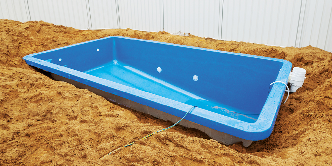 This image depicts an empty swimming pool in the ground. 