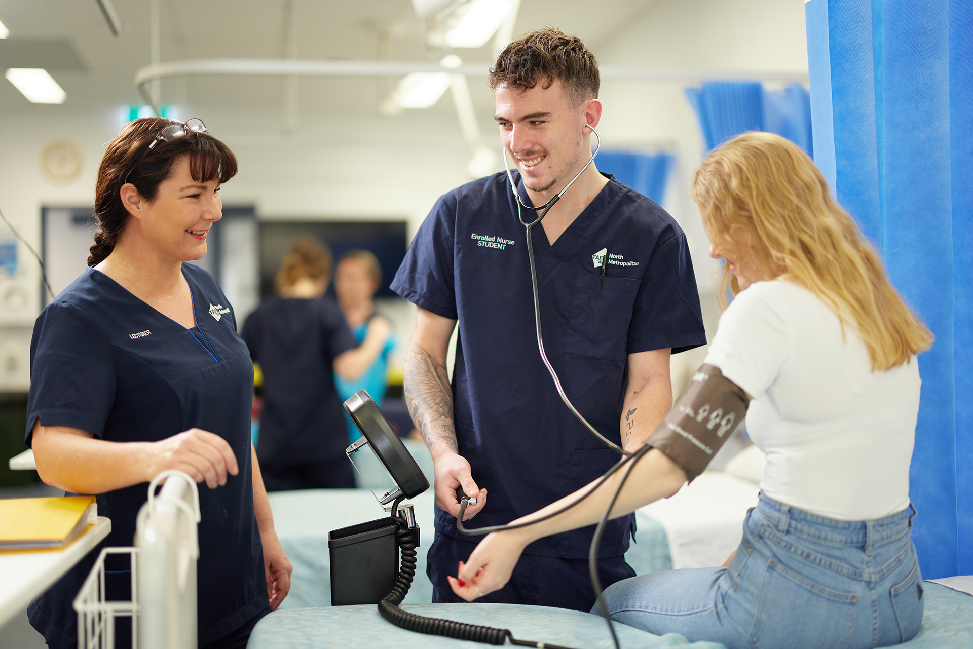 Nursing students practicing blood pressure checks in a training environment.