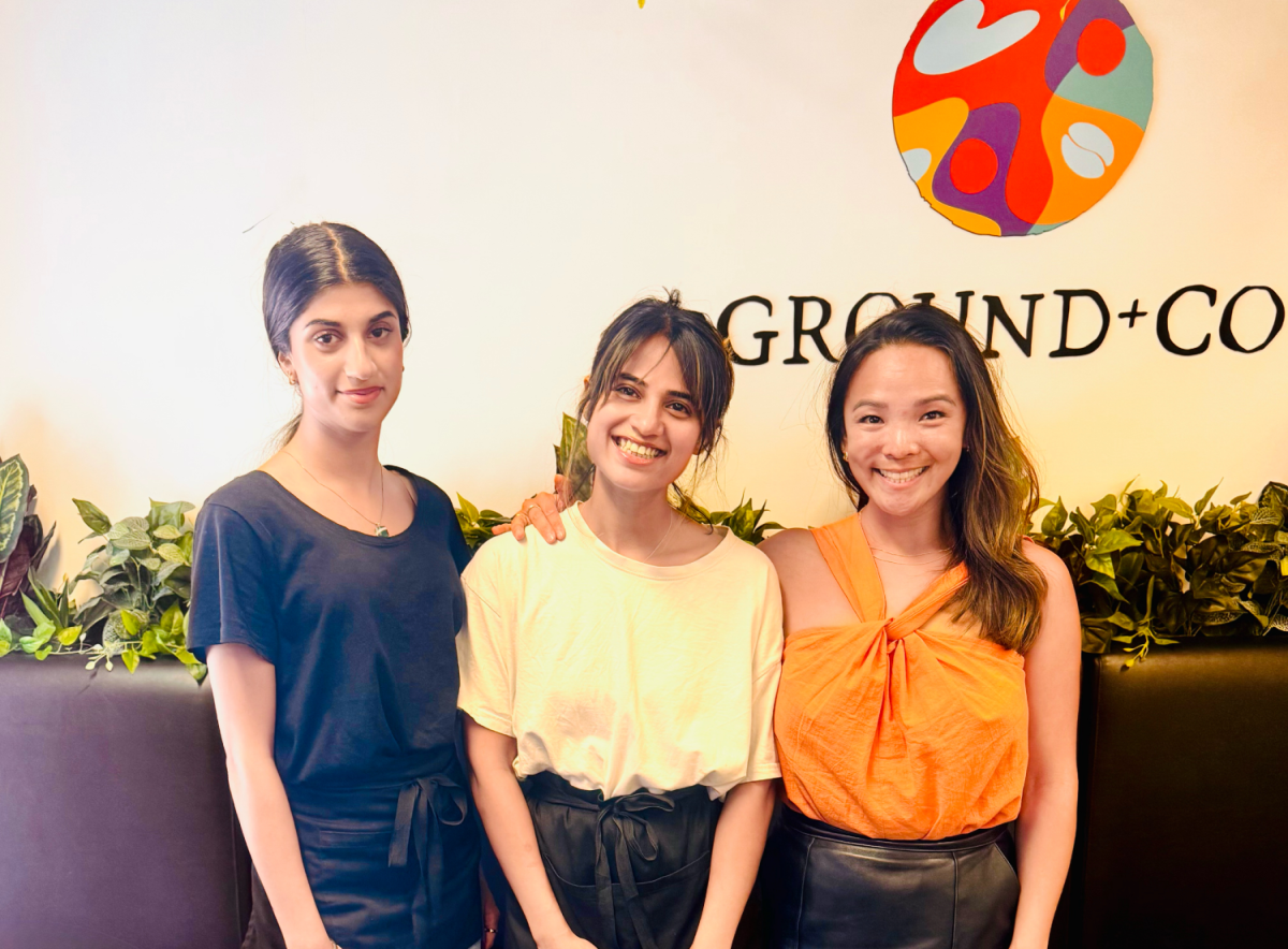 Image of three women standing outside a cafe smiling 