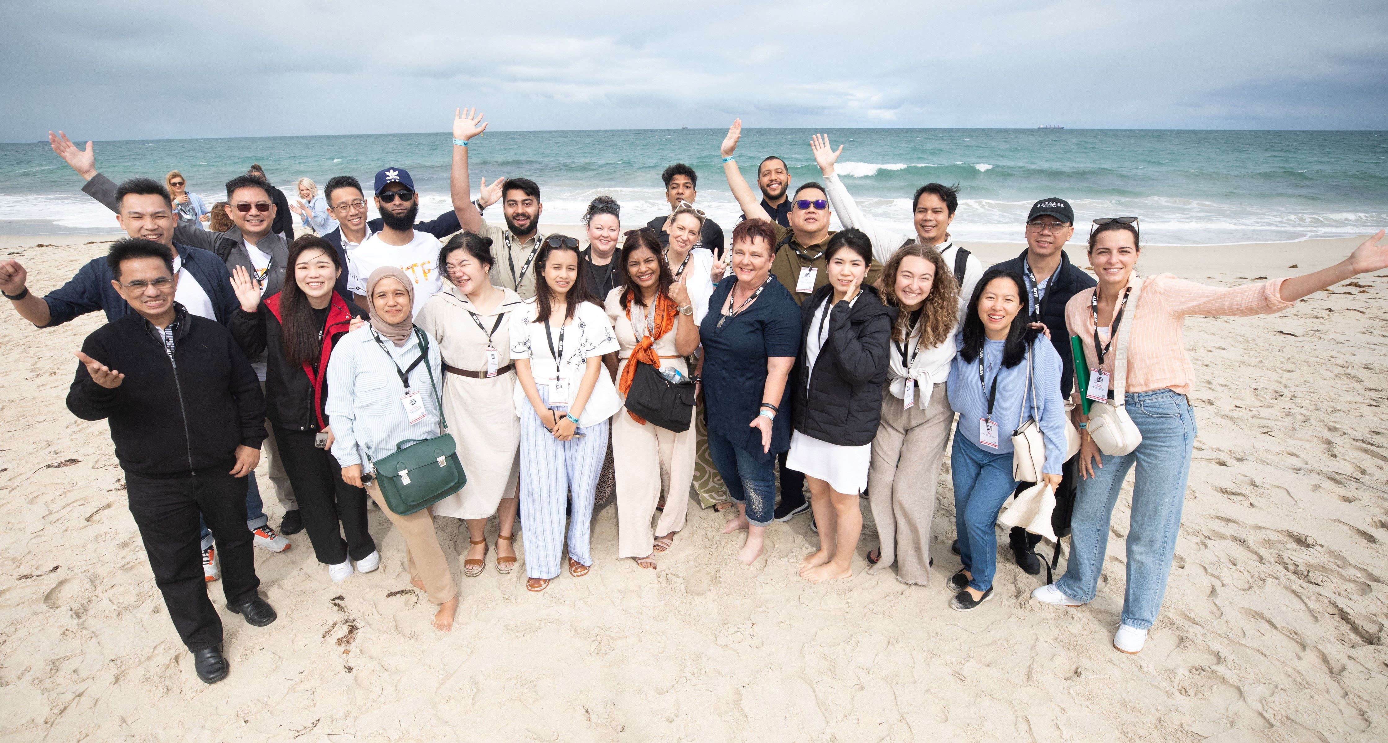 International delegates led by Invest and Trade WA wave to the camera from a WA beach 