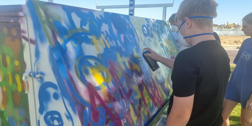 Photo of young people creating artwork with spray cans