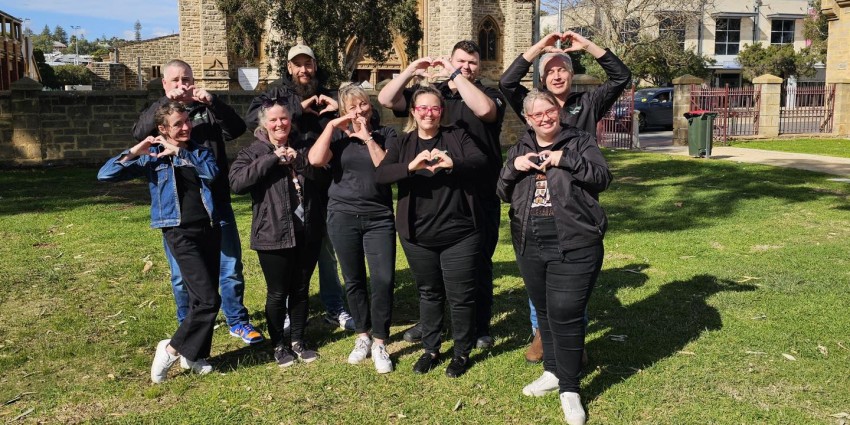 Photo of a group of people making the heart symbol with their hands