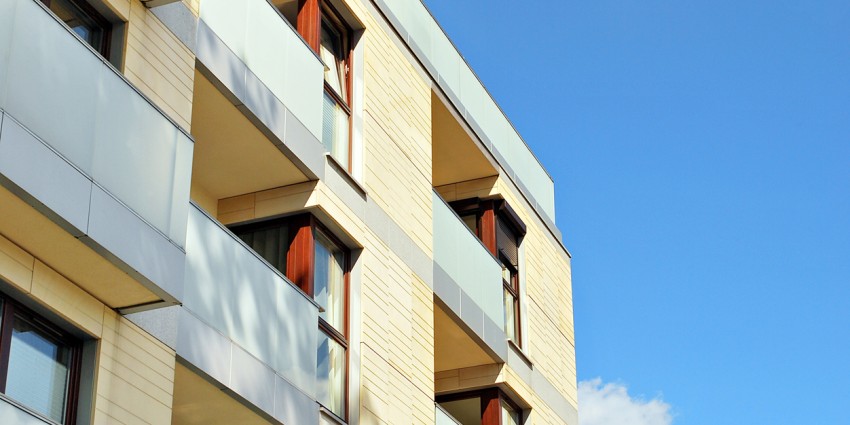 photograph of an small apartment complex with blue sky in the background