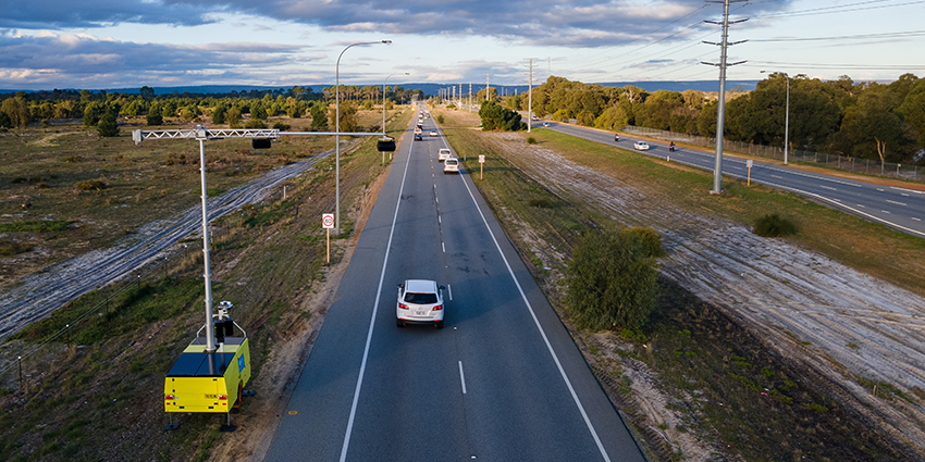 camera trailer next to a road with cars stretching out to the horizon