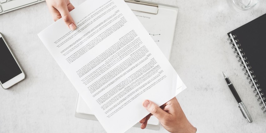 business people passing document across desk