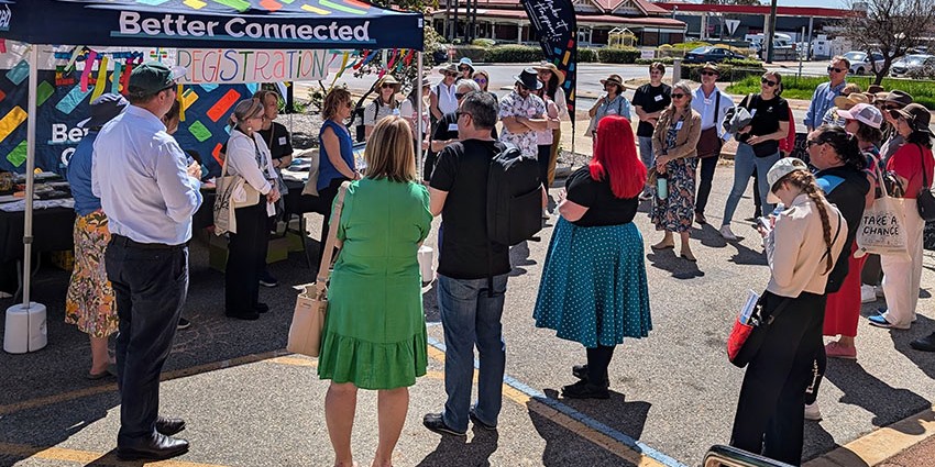 a group of people standing outside of a registration tent