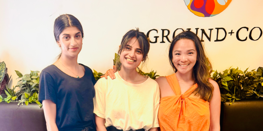 Image of three women standing outside a cafe smiling 