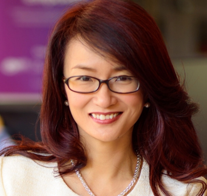 asian woman with reddish brown long hair and glasses smiling at camera